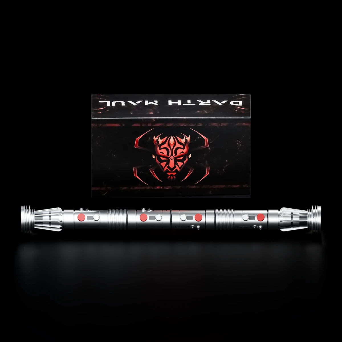 Complete silver CT054 Maul double hilt displayed in front of its illustrated collector box on a black studio background